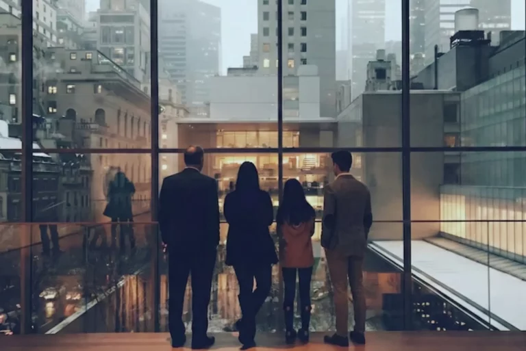 Equipo directivo observando el entorno urbano desde una oficina, símbolo de una empresa que funciona pero se encuentra en una fase de estancamiento estratégico
